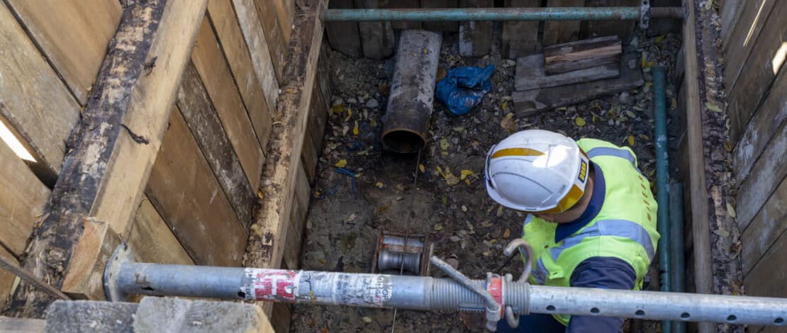 Künette mit Bauarbeiter